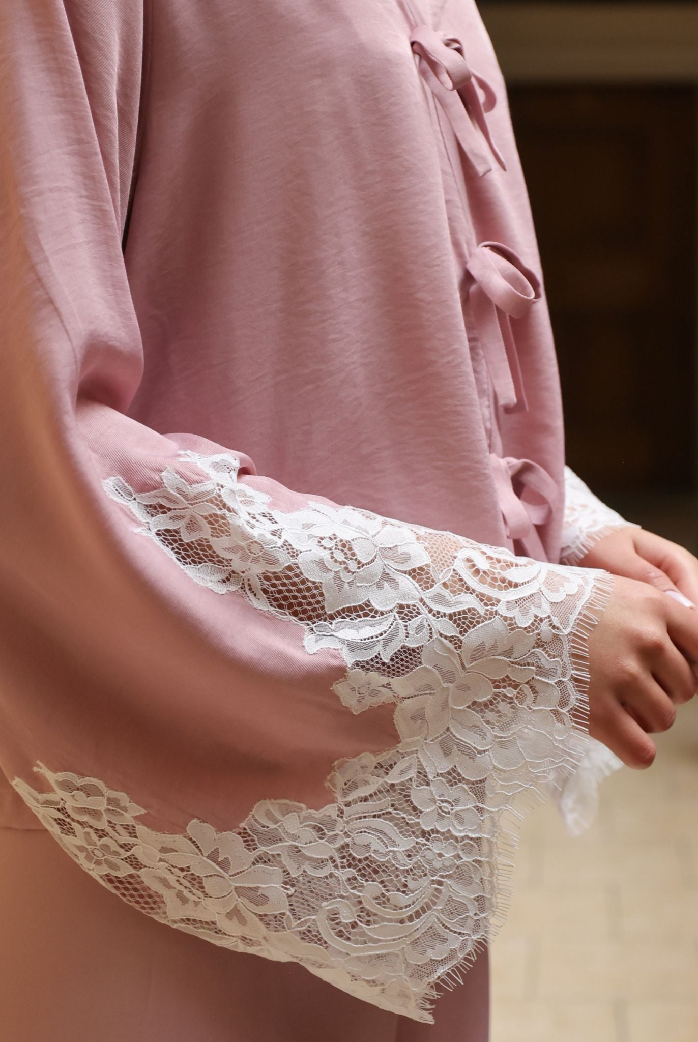 A detailed view from chest to hips, highlighting the intricately embroidered lace sleeve for a feminine contrast.
