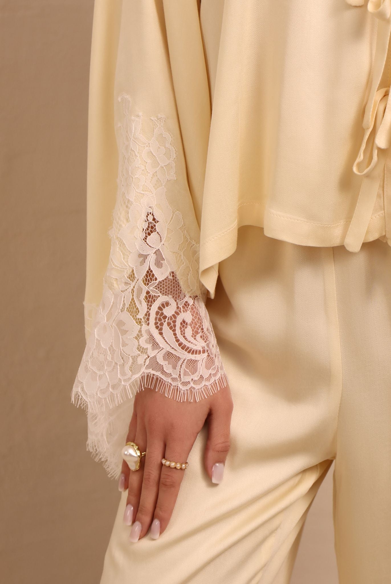 Close-up of the sleeves, featuring subtle lace detailing that adds a light, feminine contrast to the top.