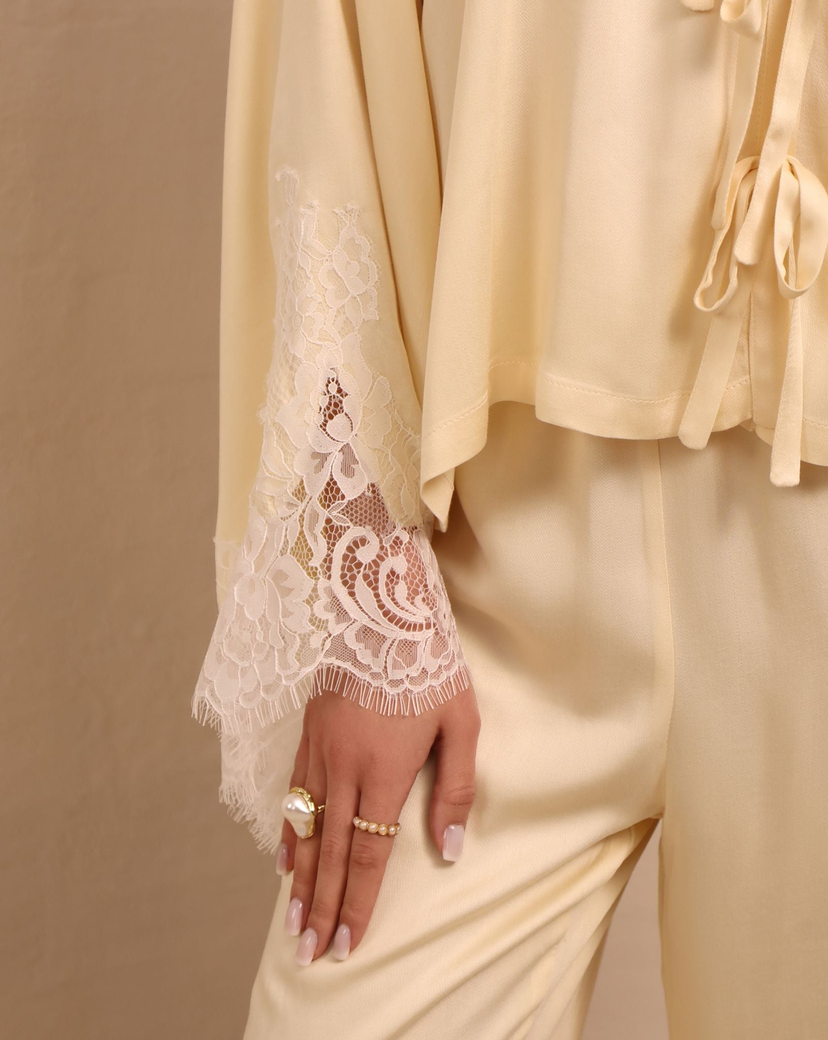 Close-up of the sleeves, featuring subtle lace detailing that adds a light, feminine contrast to the top.