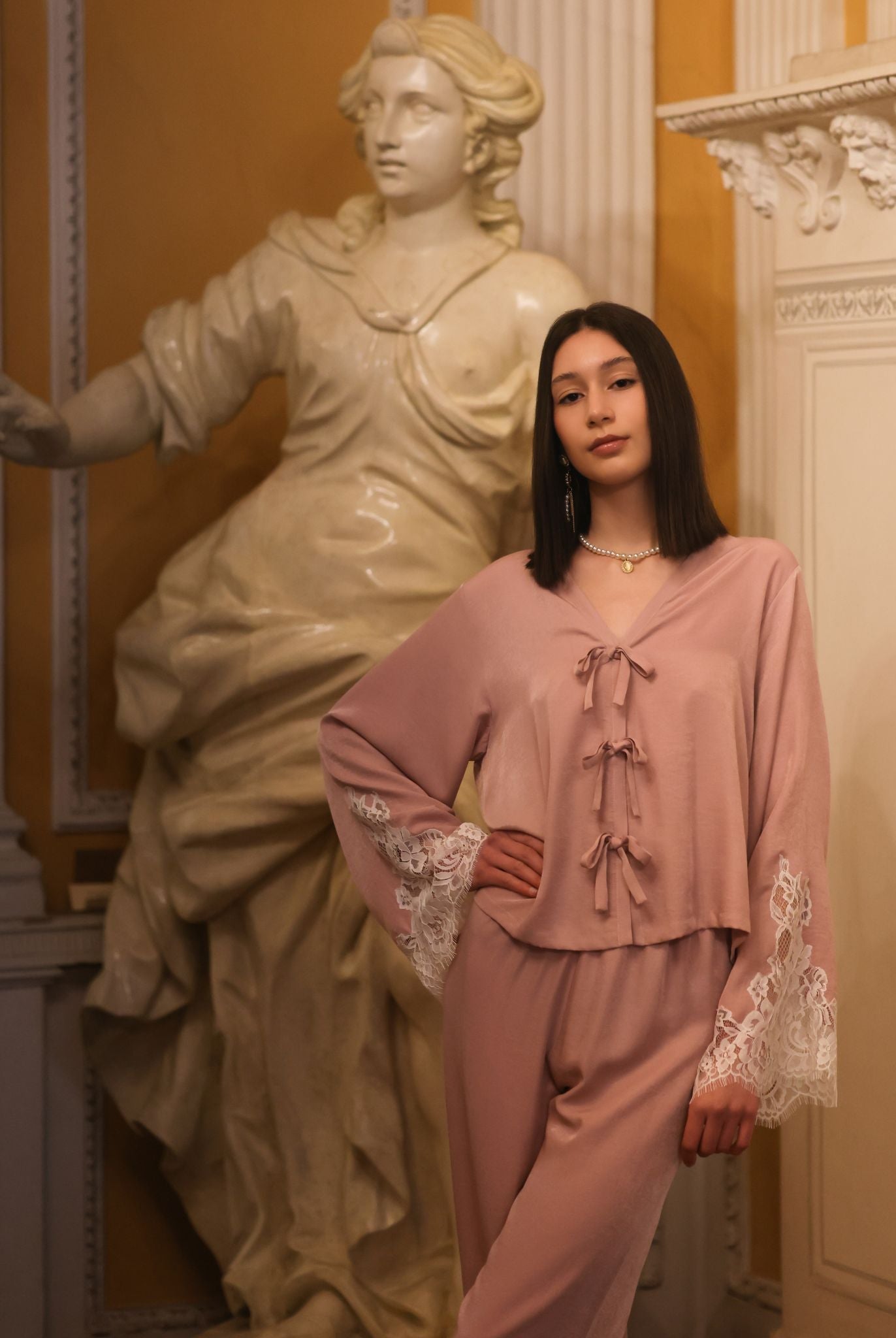 A creative shot of the set next to a sculpture, capturing the natural and elegant aesthetic of the nightwear.