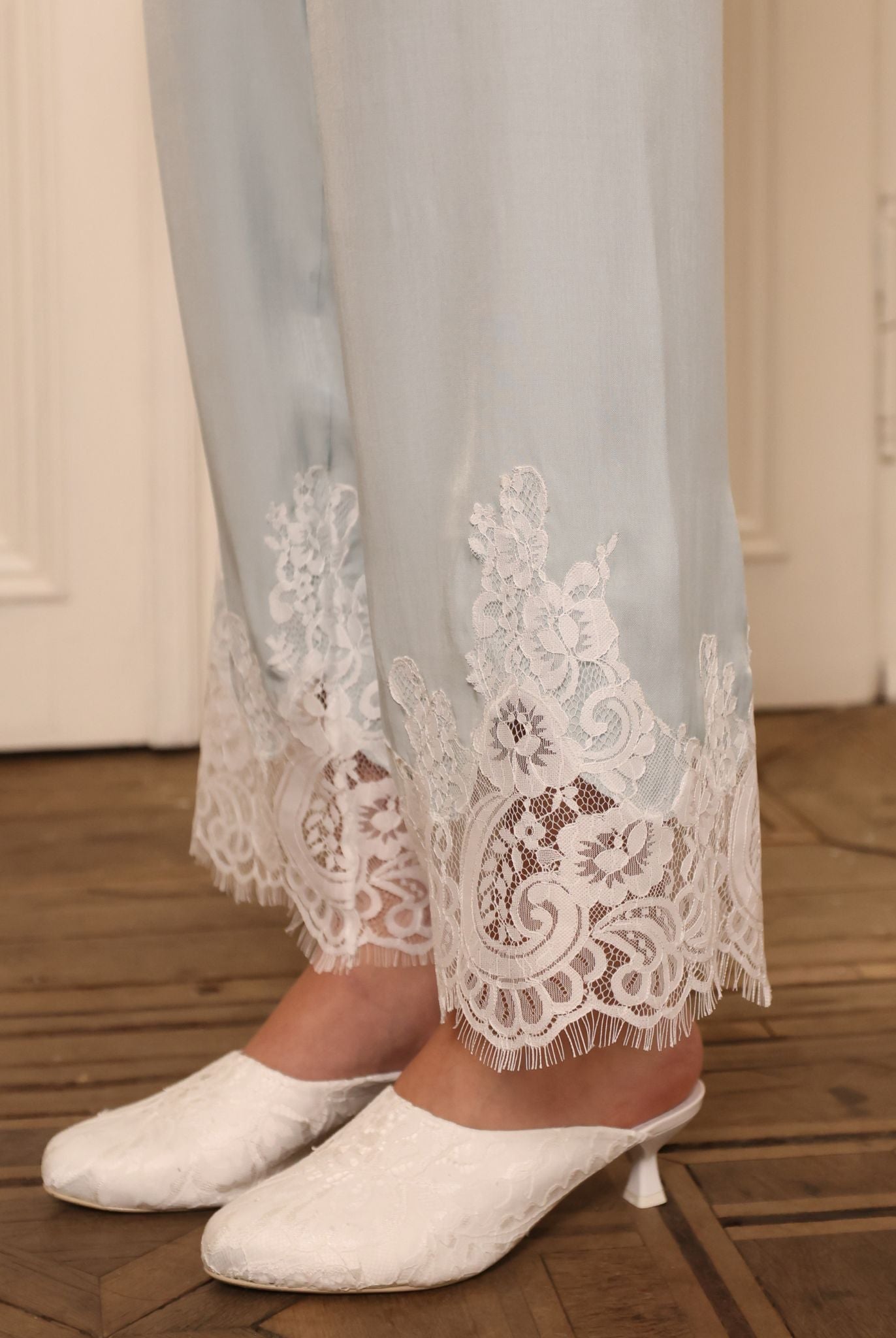 Close-up of the trouser hem, focusing on the lace accents