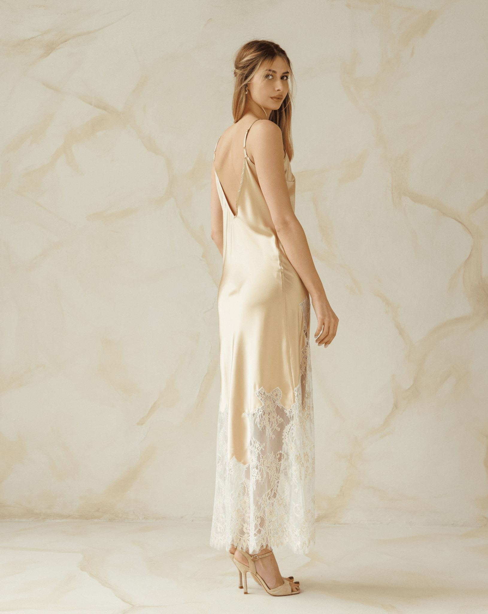 Back view of a beige nightgown with slim straps and soft lace detail