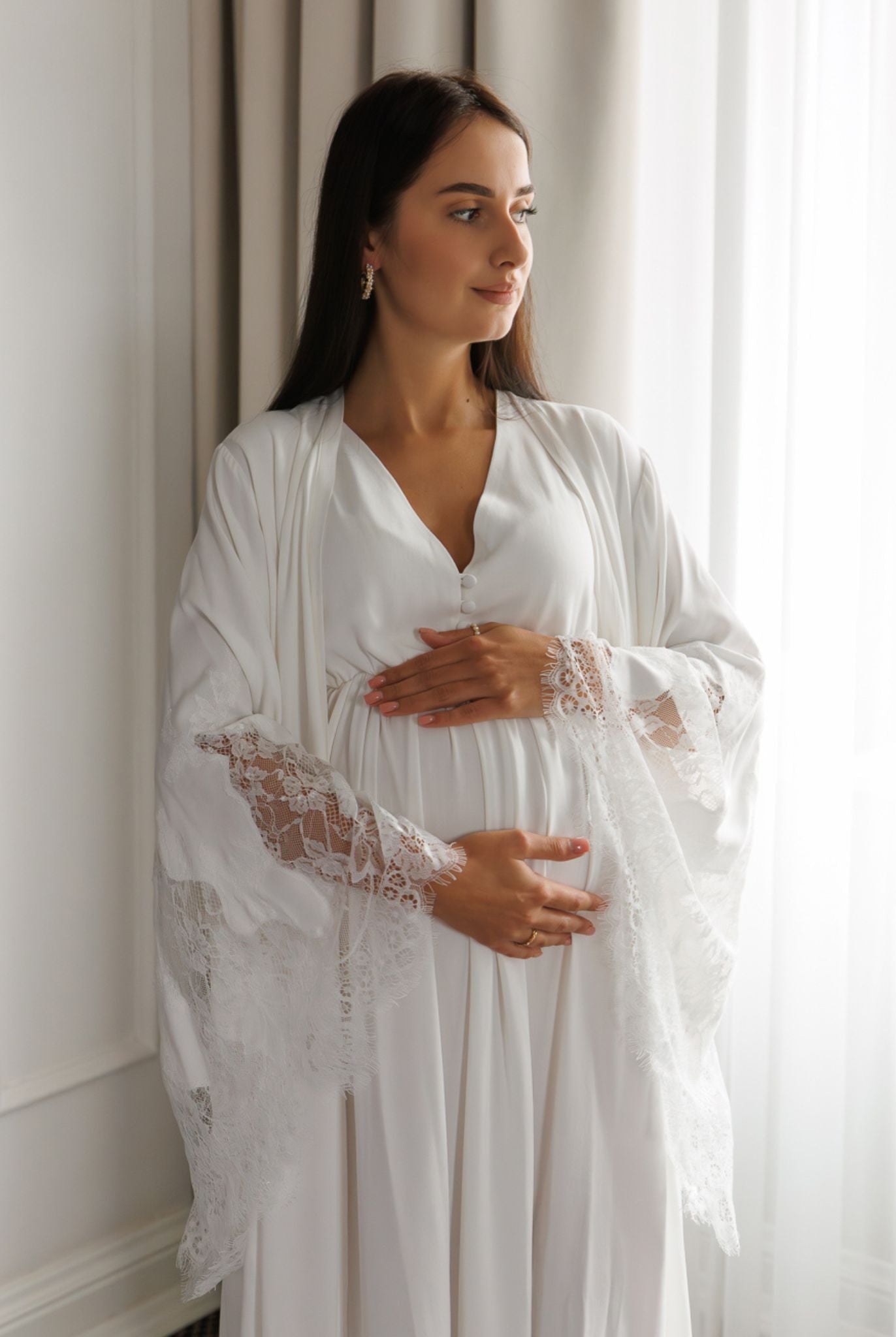 Mid-length shot of a woman holding her pregnancy bump, illustrating the practical comfort of the motherhood-focused design.