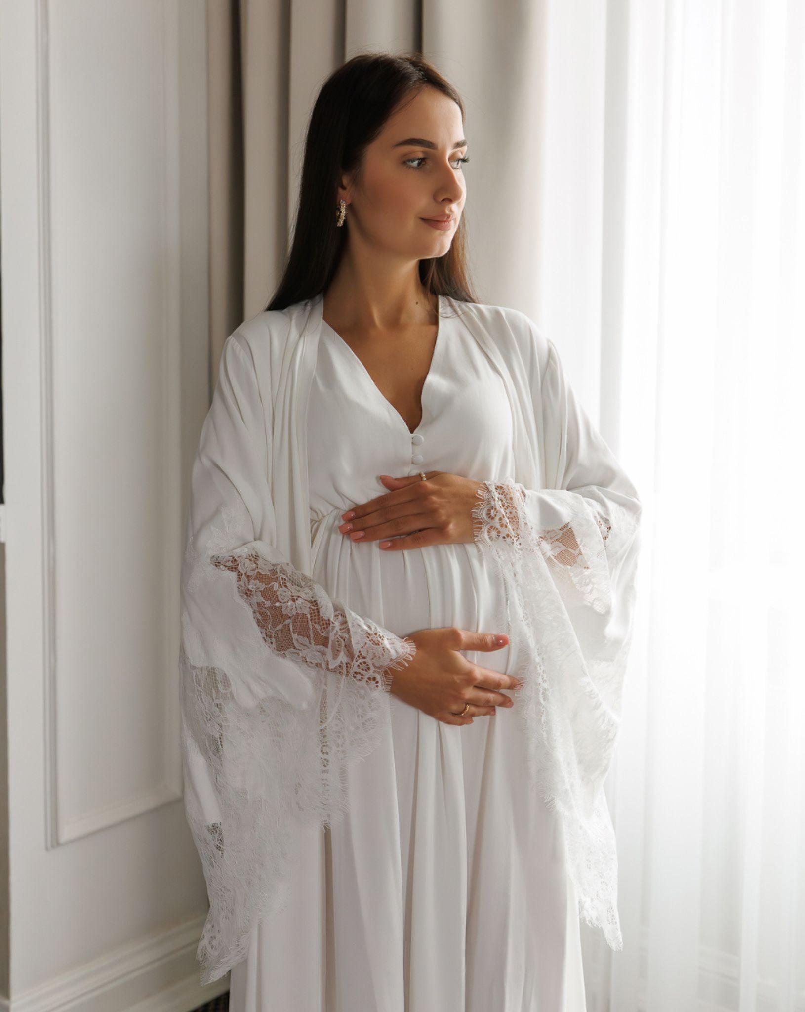 Mid-length shot of a woman holding her pregnancy bump, illustrating the practical comfort of the motherhood-focused design.