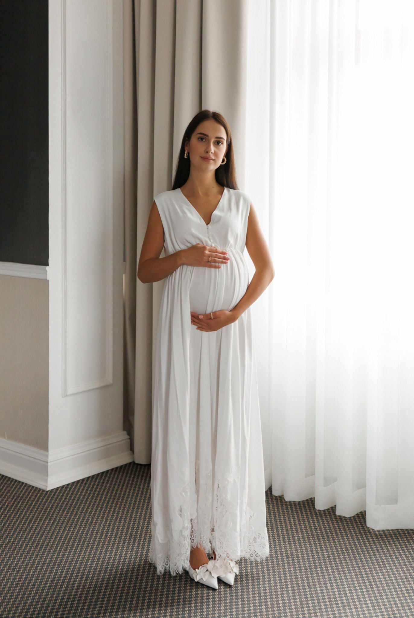 Standing in a maternity nightdress while holding the belly, featuring hidden openings for easy and quick nursing access.