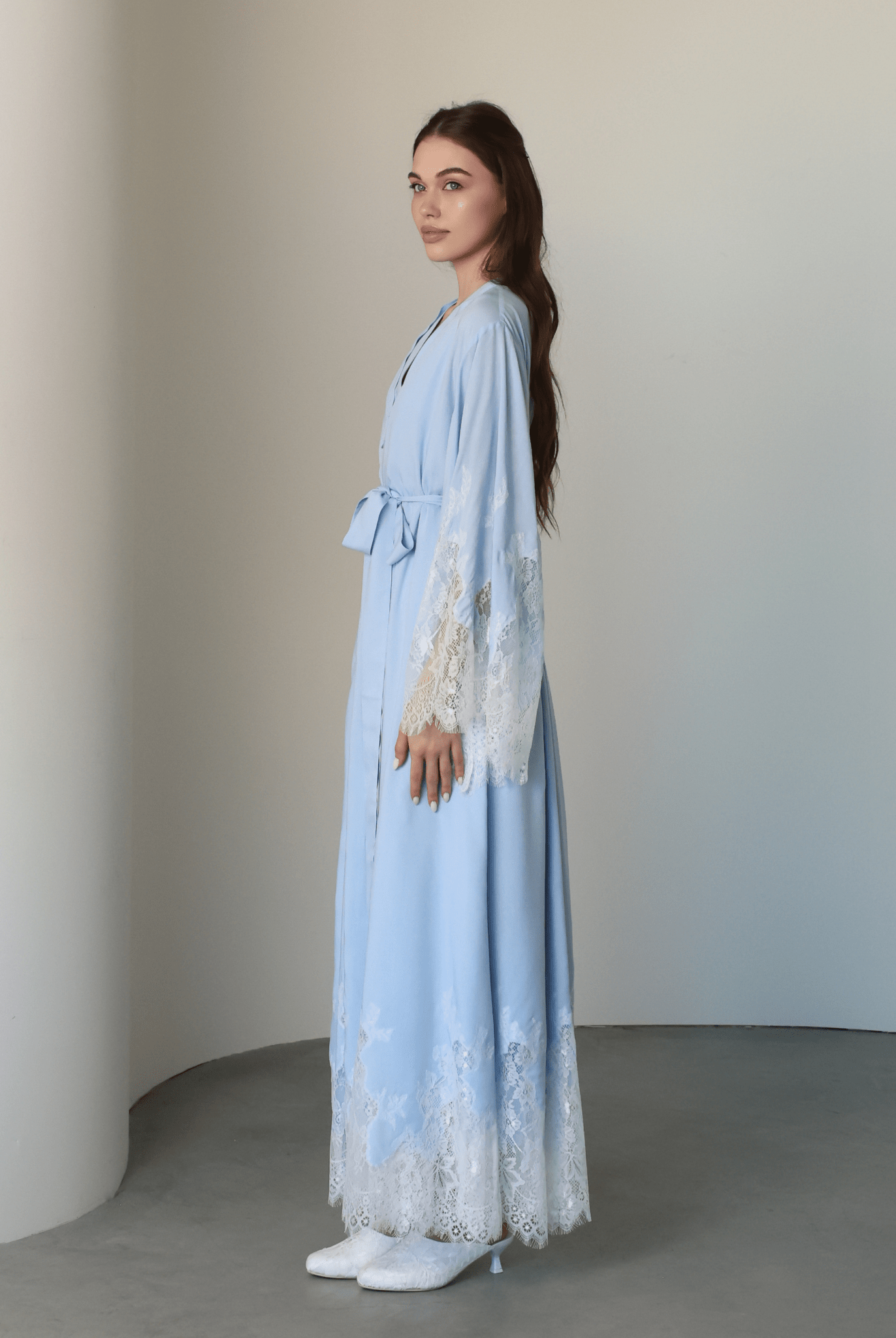 Side perspective of the long robe and gown, reaching the ankles for an elegant and elongated silhouette at home.