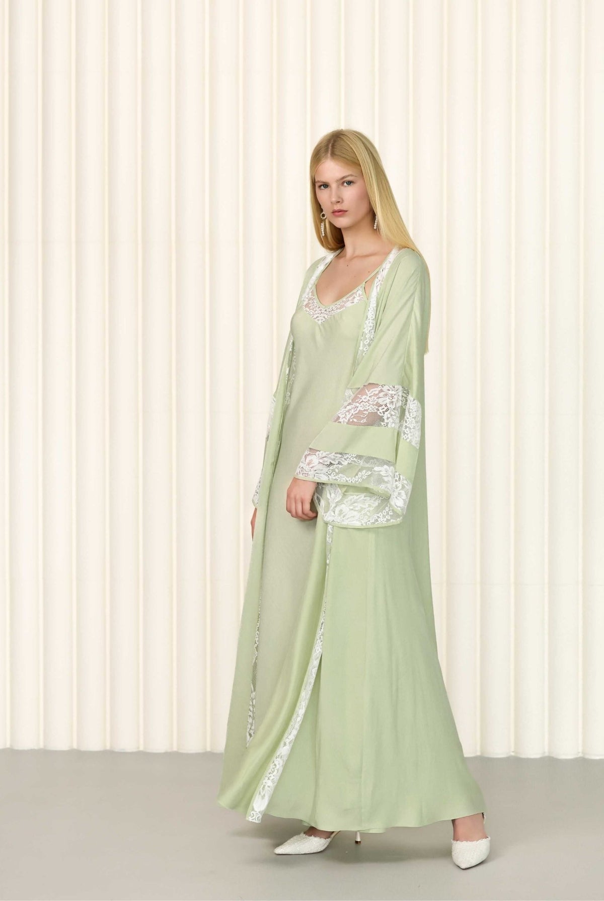 Side pose of model wearing embroidered sage robe over nightgown