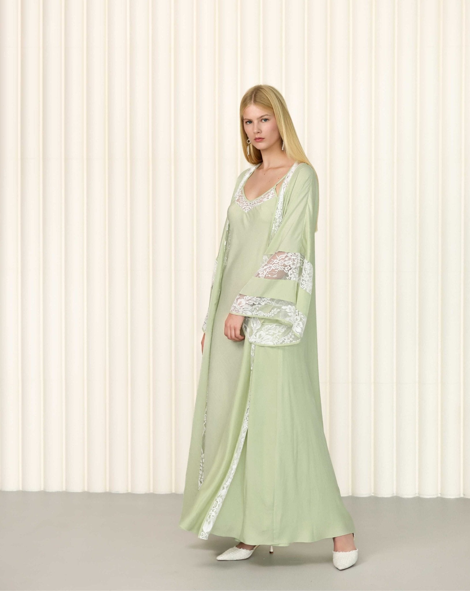 Side pose of model wearing embroidered sage robe over nightgown