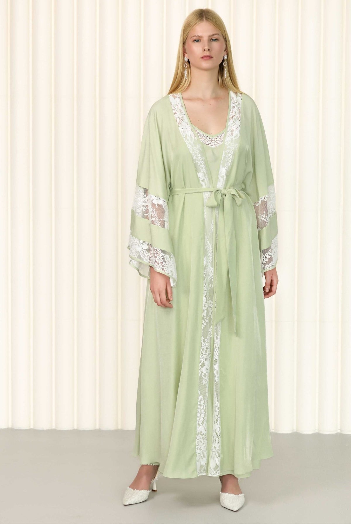 Frontal view of embroidered green robe set styled with flat sandals