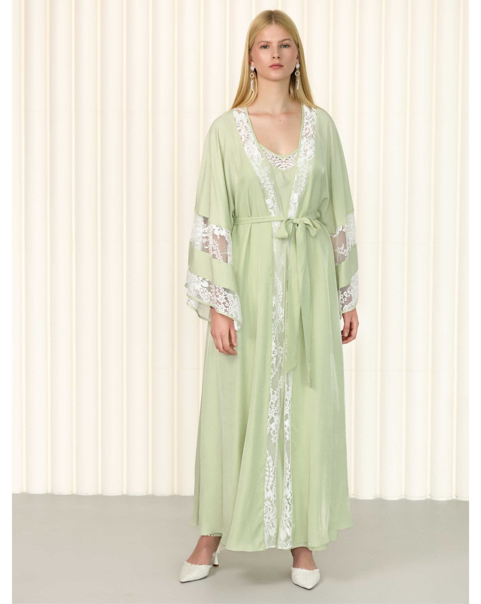 Frontal view of embroidered green robe set styled with flat sandals