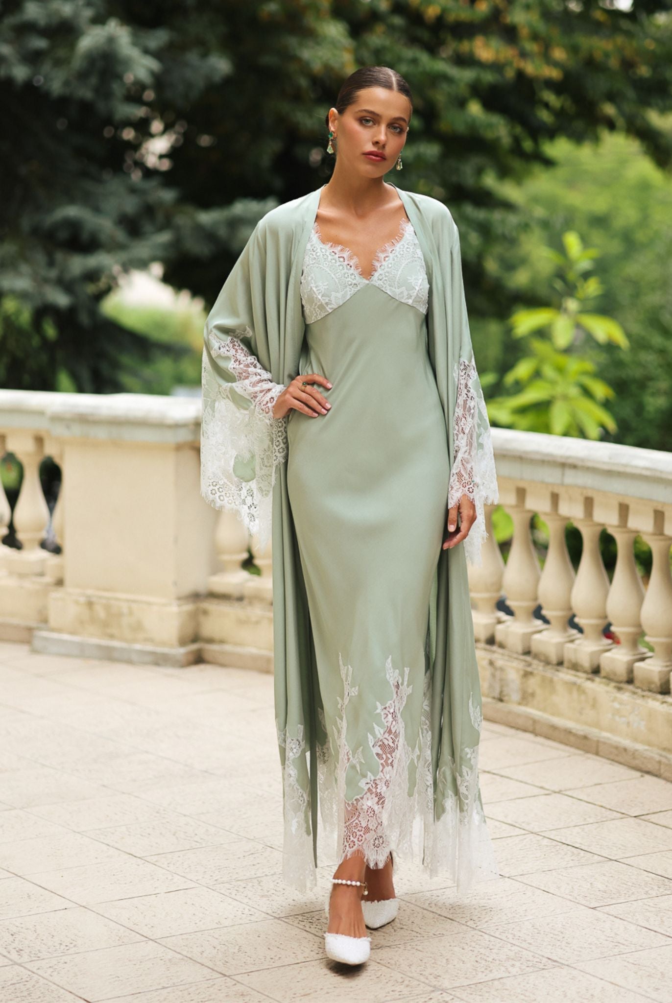Full-length standing view with one hand on the hip, showcasing the floor-length robe and its graceful drape.
