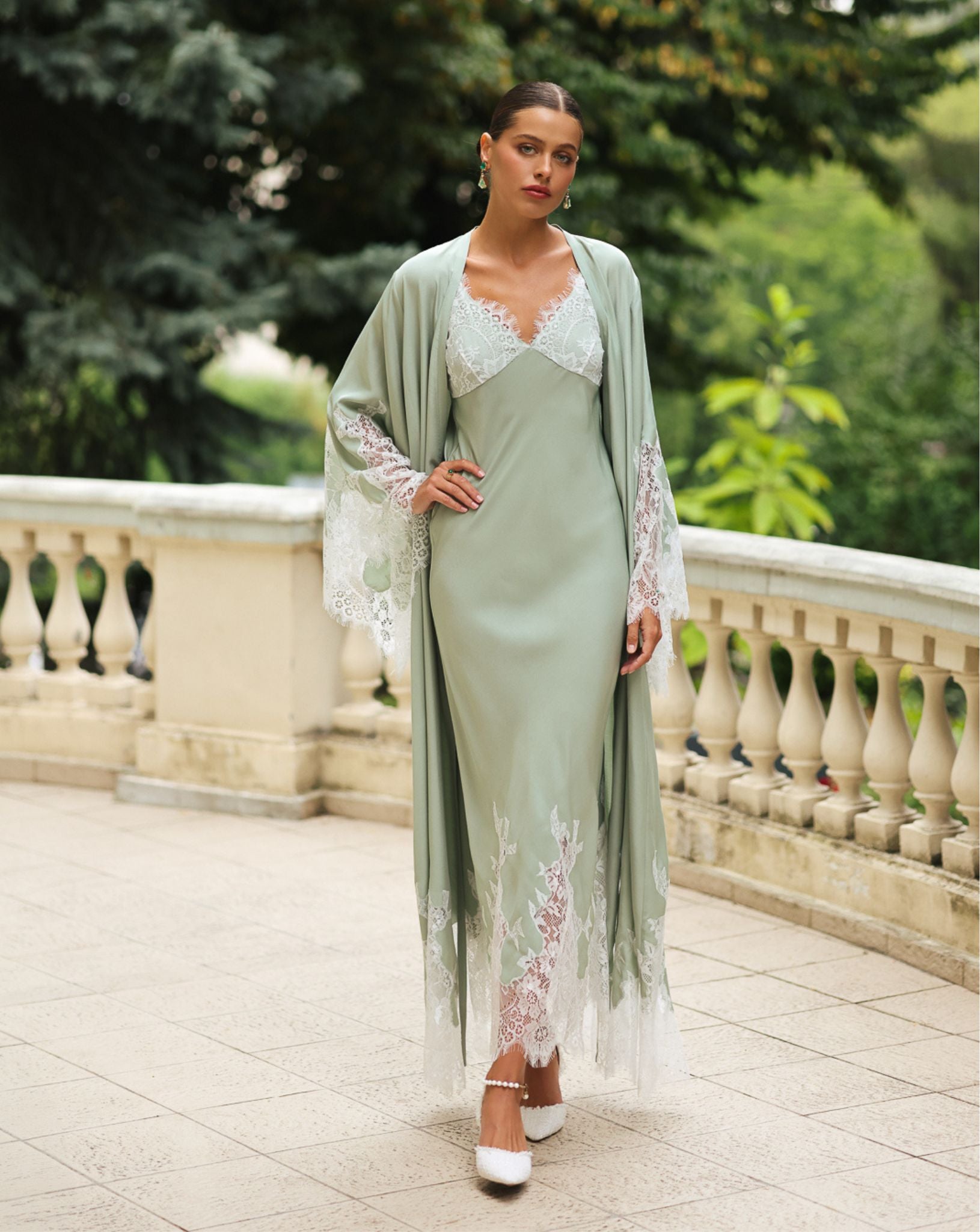 Full-length standing view with one hand on the hip, showcasing the floor-length robe and its graceful drape.