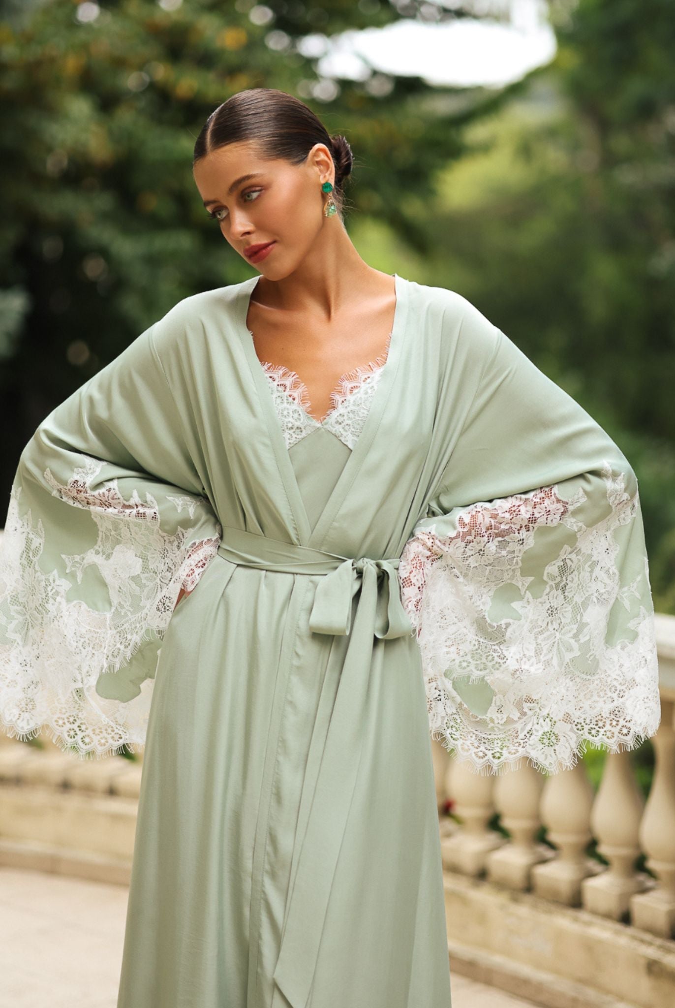 Mid-length shot with hands on the hips to display the wide sleeves and the natural softness of the light fabric.
