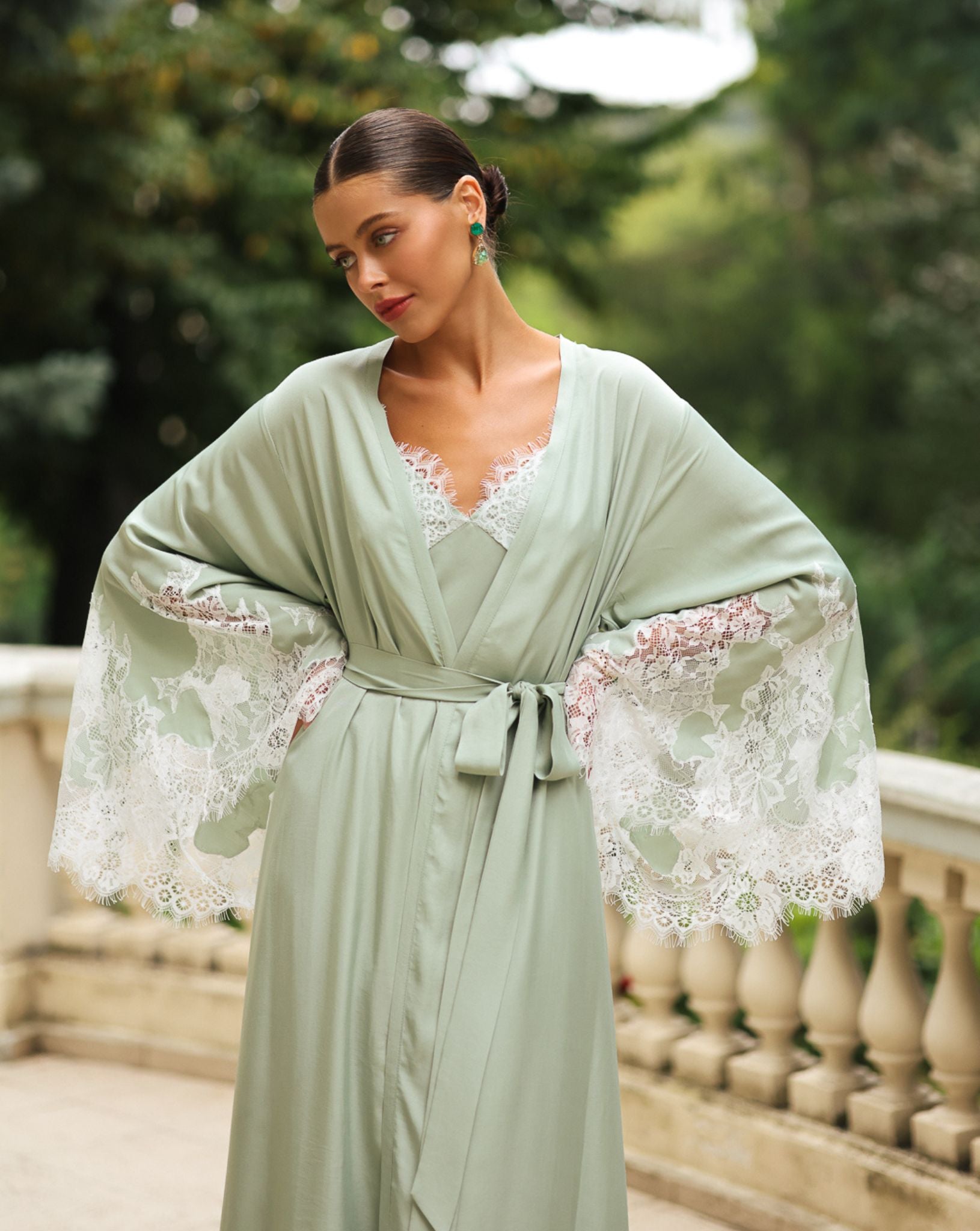 Mid-length shot with hands on the hips to display the wide sleeves and the natural softness of the light fabric.
