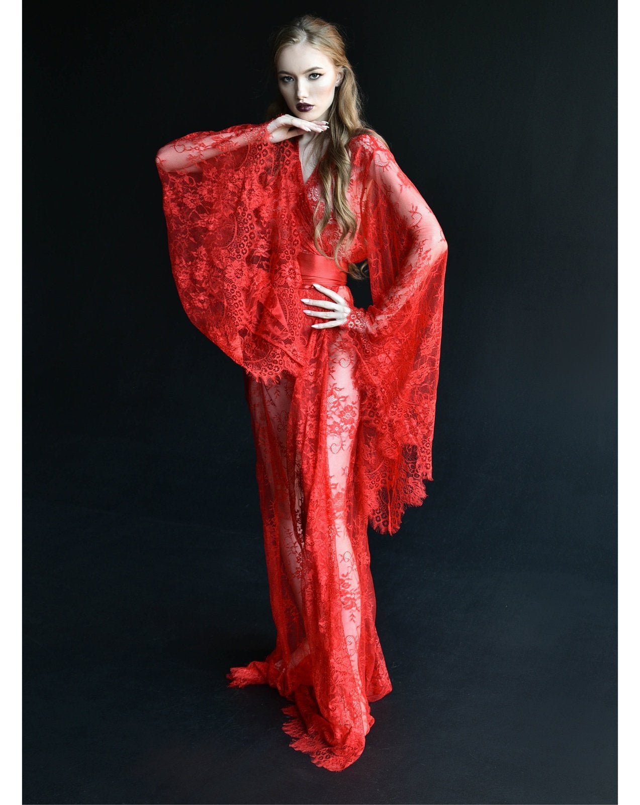 Red sheer lace robe with dramatic sleeves against black backdrop