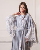 Waist-up shot of a robe tied with a tassel belt, highlighting the defined silhouette and lace details.