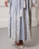 Detail of the robe's hem featuring soft French lace and decorative tassels for a touch of style.