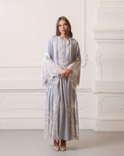 Front view with raised arms to display the exquisite wide lace sleeves of the modest floor-length robe.