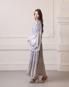 Side profile in a lace robe, showcasing the floor-length drape and elegant floral patterns.