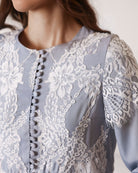 Close-up of fabric-covered buttons and French lace on a nightdress, perfect for breastfeeding access.
