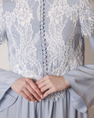 Detailed shot of the high neckline, lace inserts, and small buttons on a modest viscose garment.