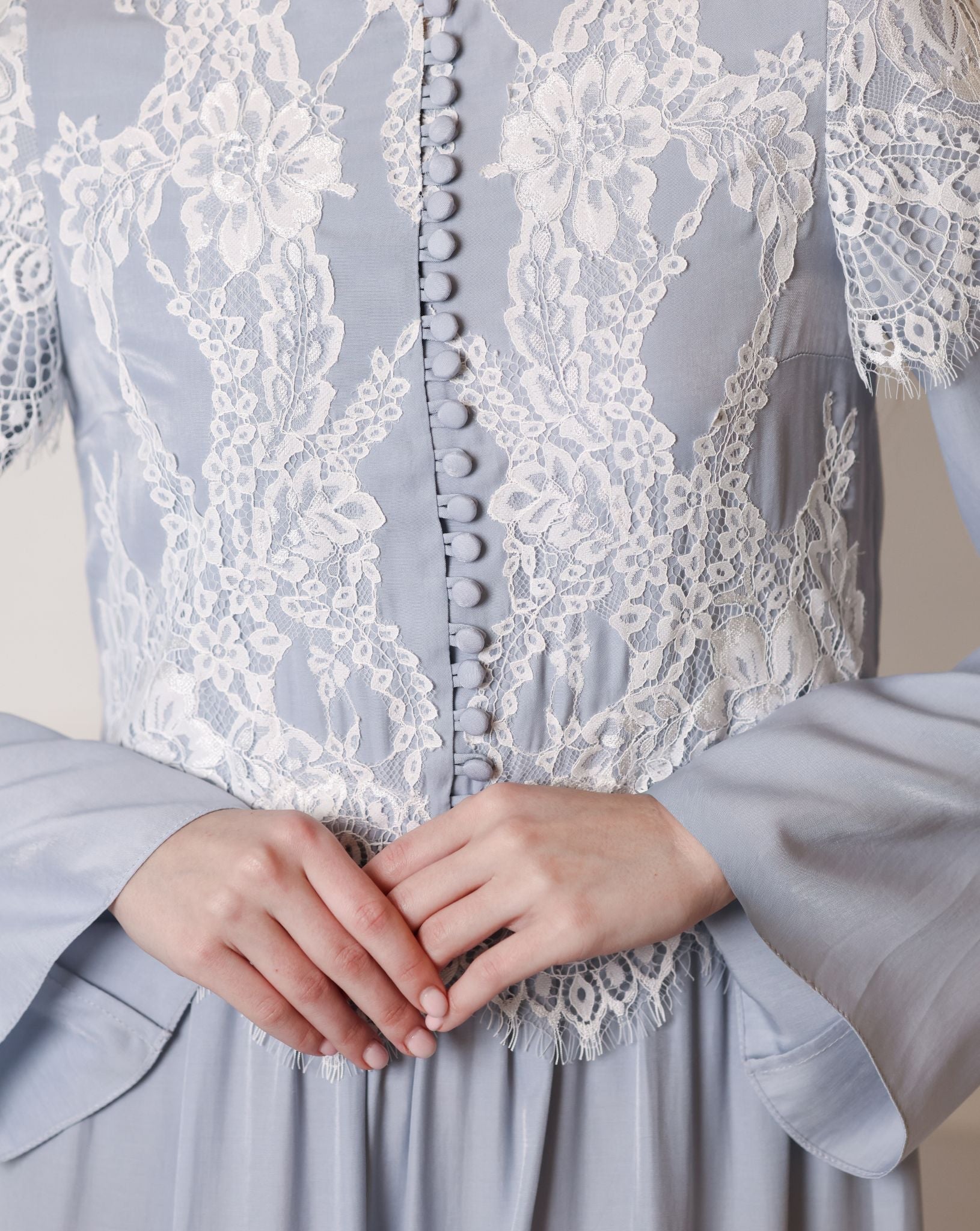 Detailed shot of the high neckline, lace inserts, and small buttons on a modest viscose garment.