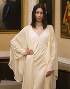 A mid-length shot focusing on the lace appliqué at the bodice and the wide sleeves edged in delicate lace.