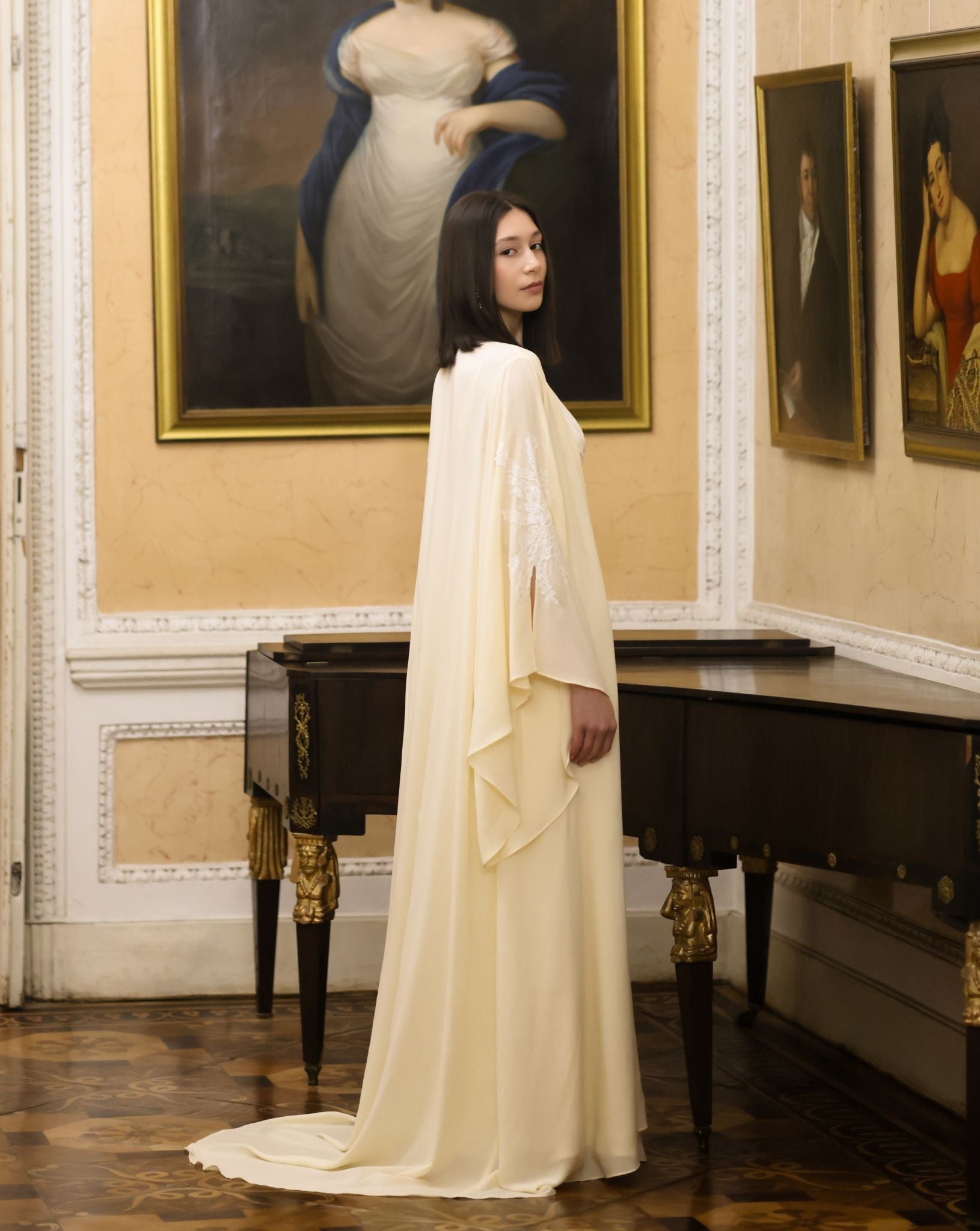A poised shot near a piano, showcasing the Robe and Nightgown Set with its elegant and weightless long train.