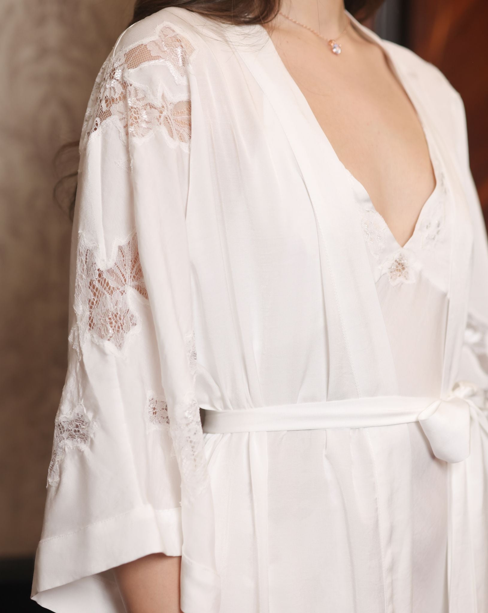 Close-up from head to waist focusing on the intricate lace textures and the delicate artistry of the sleeves.