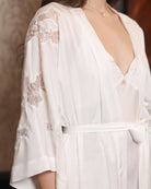 Close-up from head to waist focusing on the intricate lace textures and the delicate artistry of the sleeves.