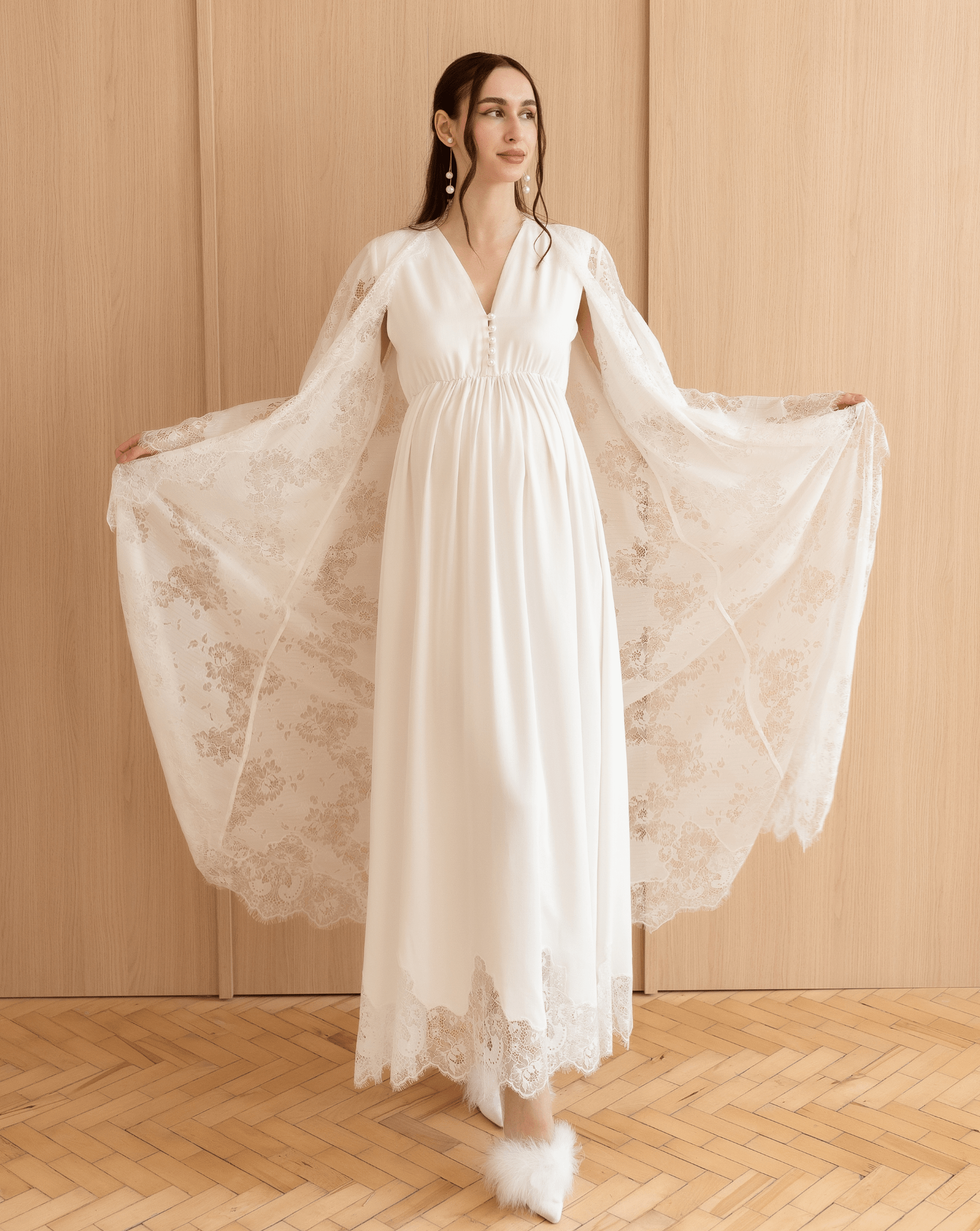 Kafemme model showcasing wide lace sleeves of the robe