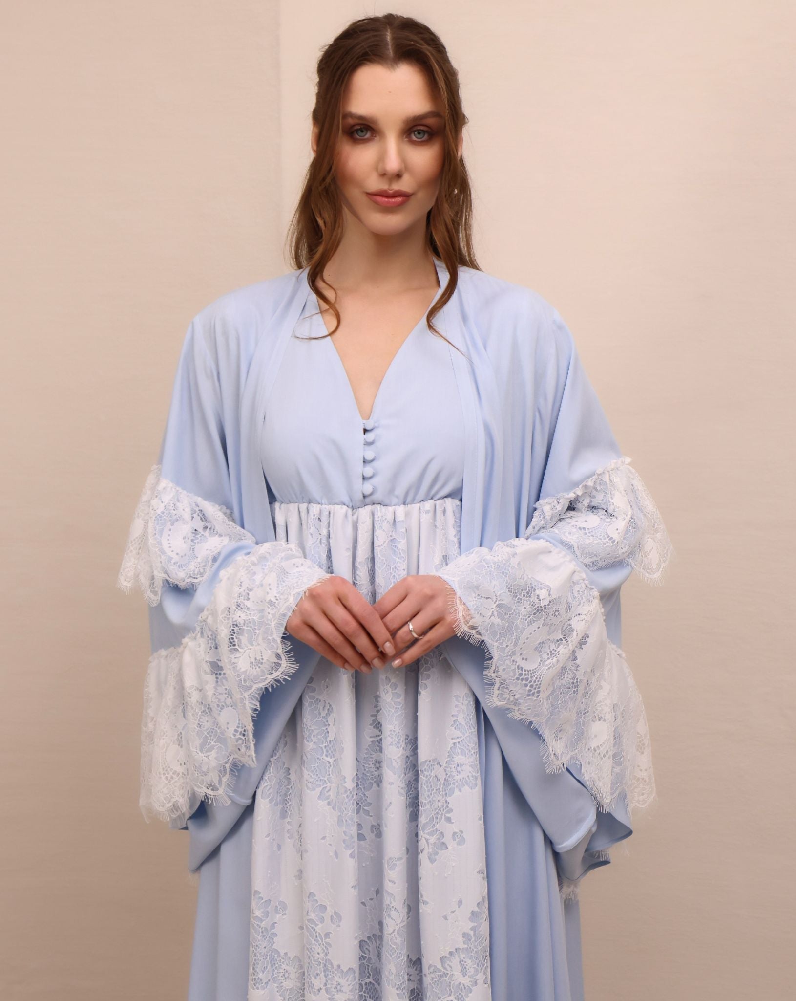 A mid-length shot focusing on the tiered bell sleeves with lace ruffles and the delicate buttoned neckline.