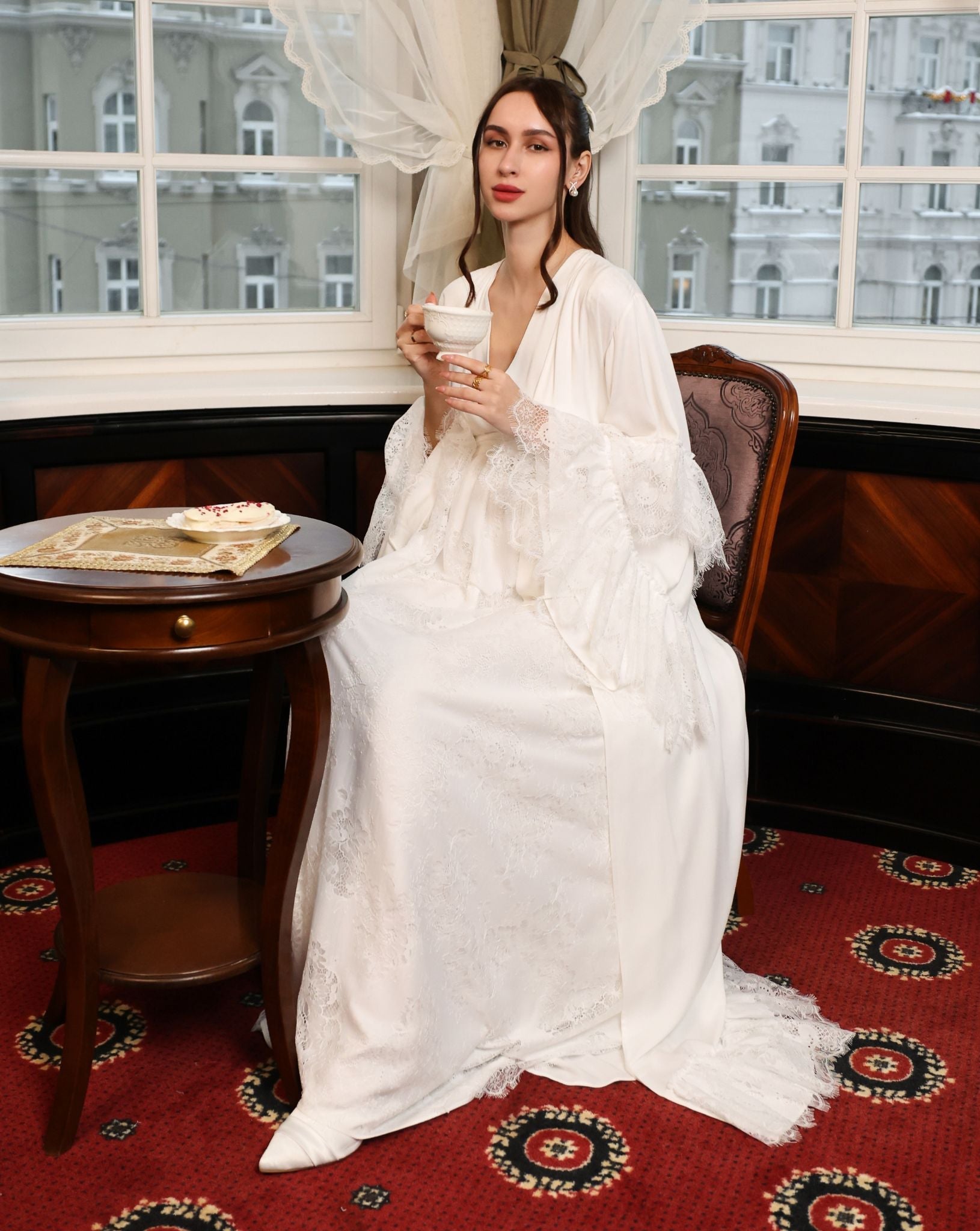 A creative seated pose in the cotton wrap, highlighting the delicate ruffles and the luxurious feel of the material.