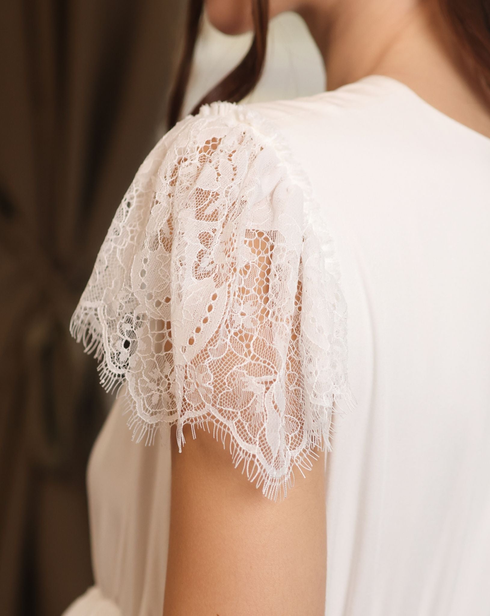 Detailed view of the nightgown's sleeve, highlighting the fine lace trim and the soft texture of the cotton blend.