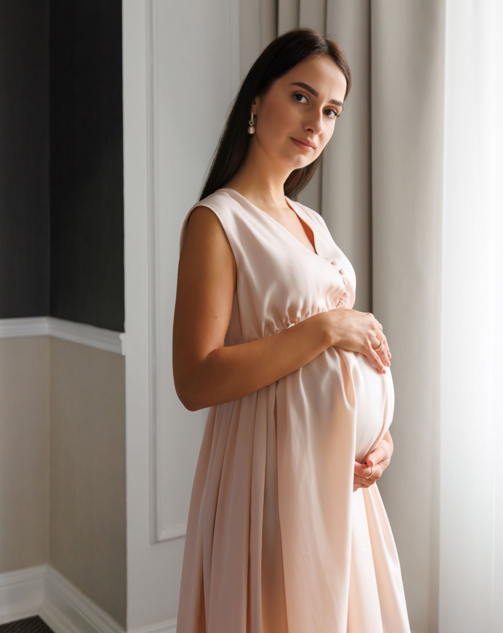 Side view from head to knees in a soft cotton nightdress, emphasizing the gentle silhouette and refined maternity look.