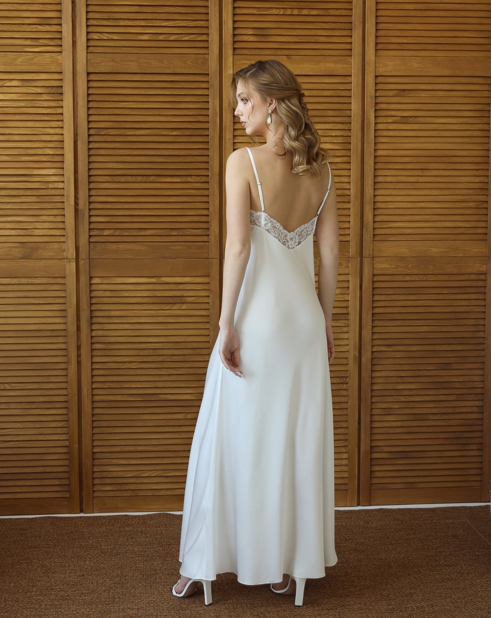 Back view of bride wearing long white nightgown and matching robe