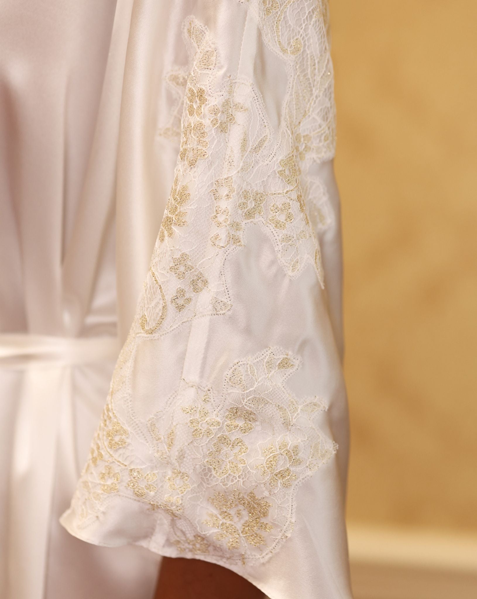 Close-up of gold floral embroidery on white satin kaftan – KÂfemme