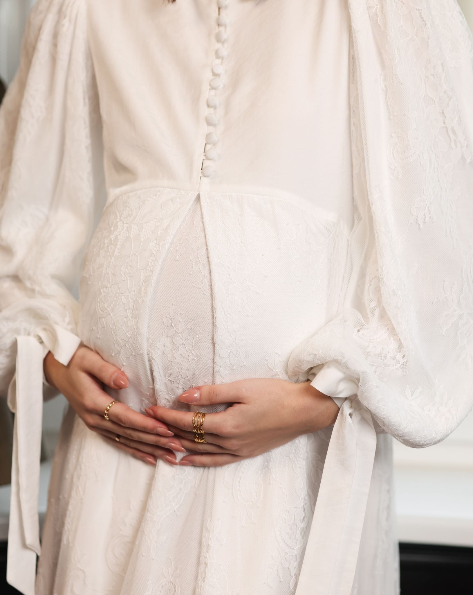 Close-up from neck to waist, showing the satin buttons that provide discreet and comfortable breastfeeding access.