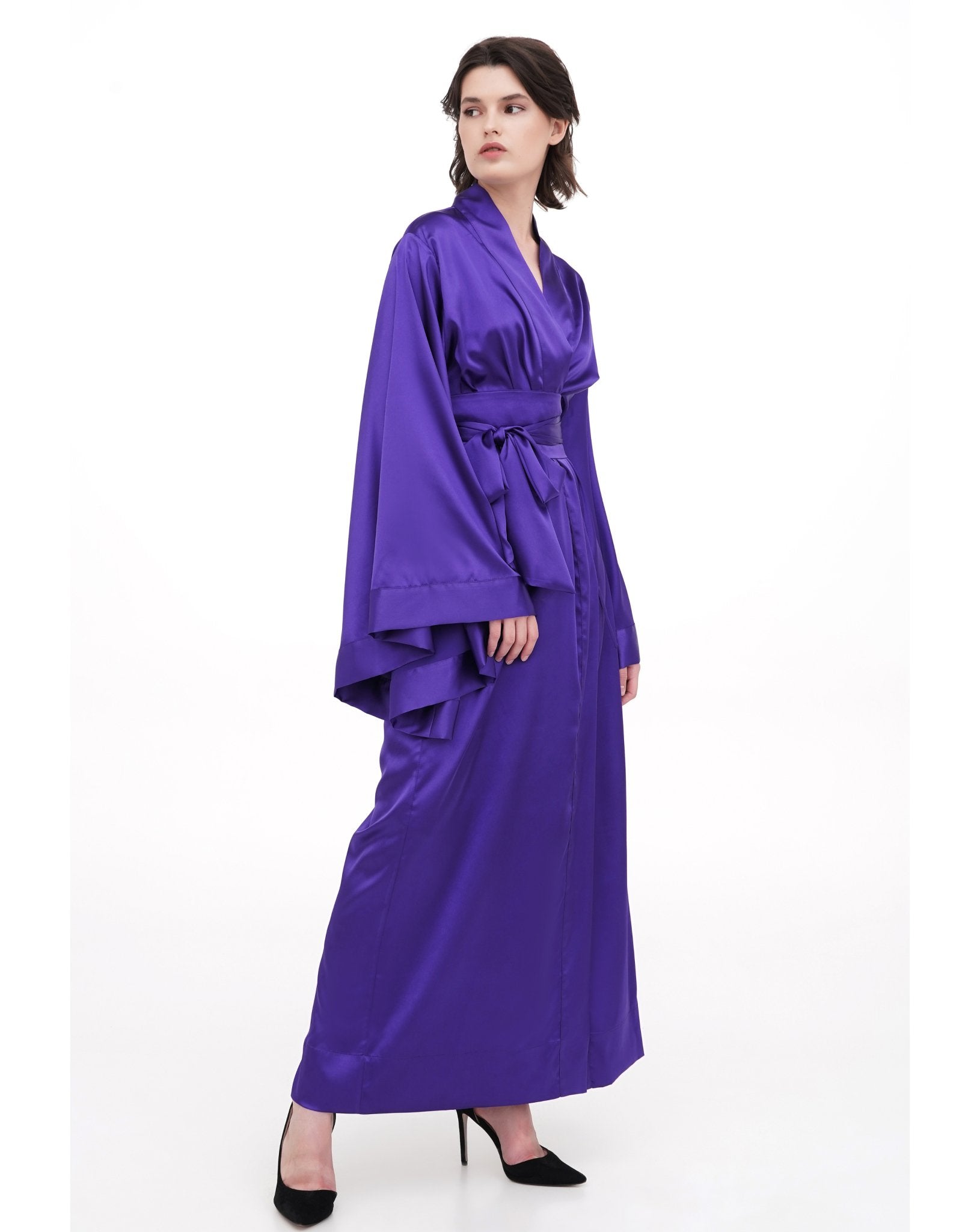 Side profile of a floor-length purple kimono, emphasizing the elegant drape and fluid movement of the high-quality fabric.