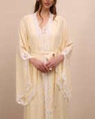 A mid-length shot focusing on the intricate lace and sleeve slits that add movement to the elegant silhouette.