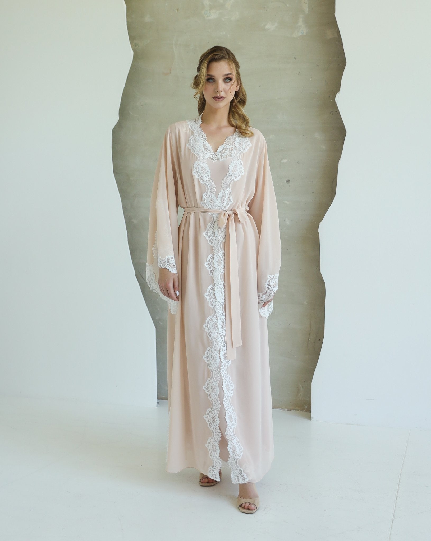 Woman facing forward in full-length beige nightwear set with lace detailing