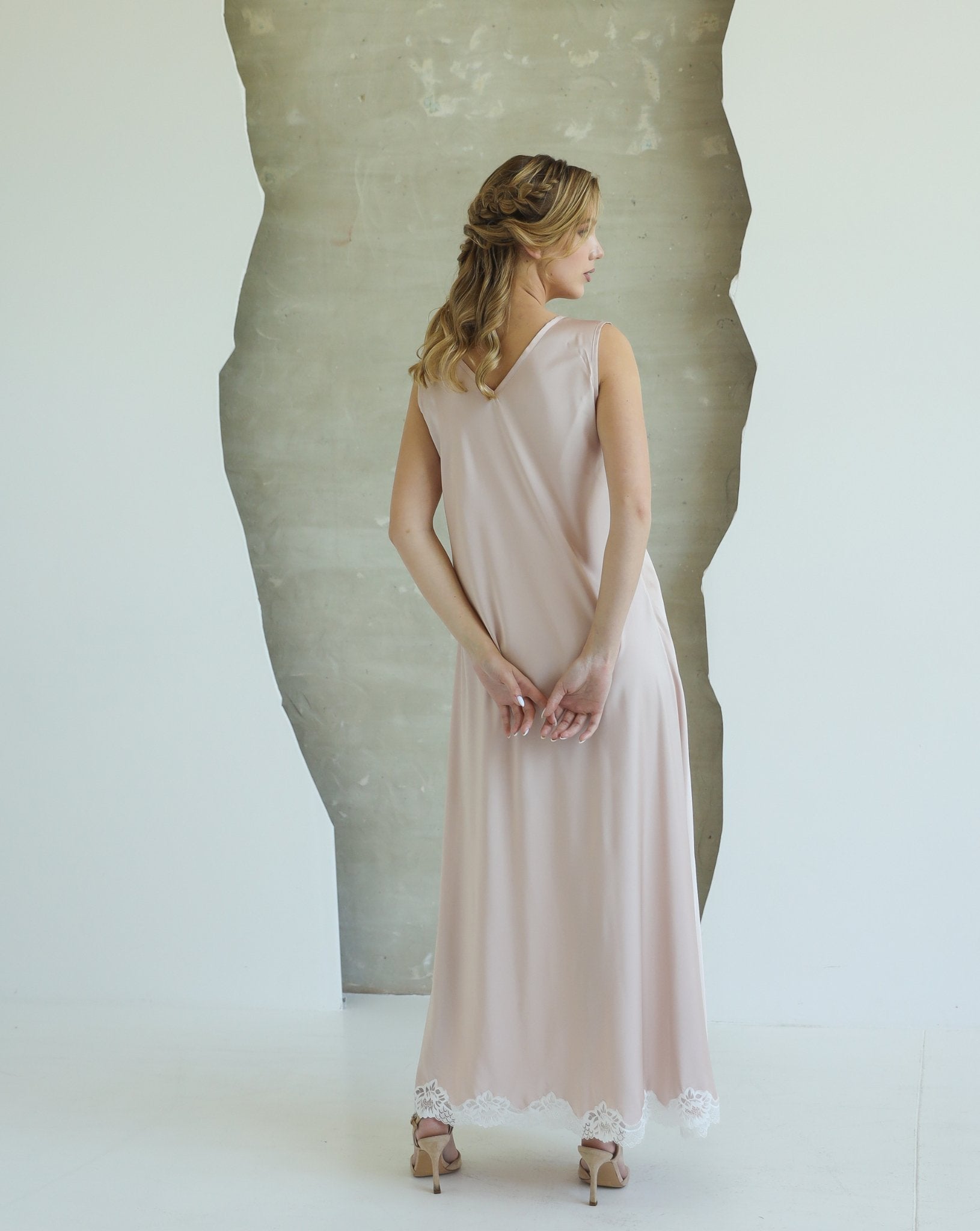Back view of woman in long beige nightgown with delicate drape