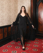 Motion shot of the ensemble, capturing the soft train of the robe and the fluid movement of the fabric.