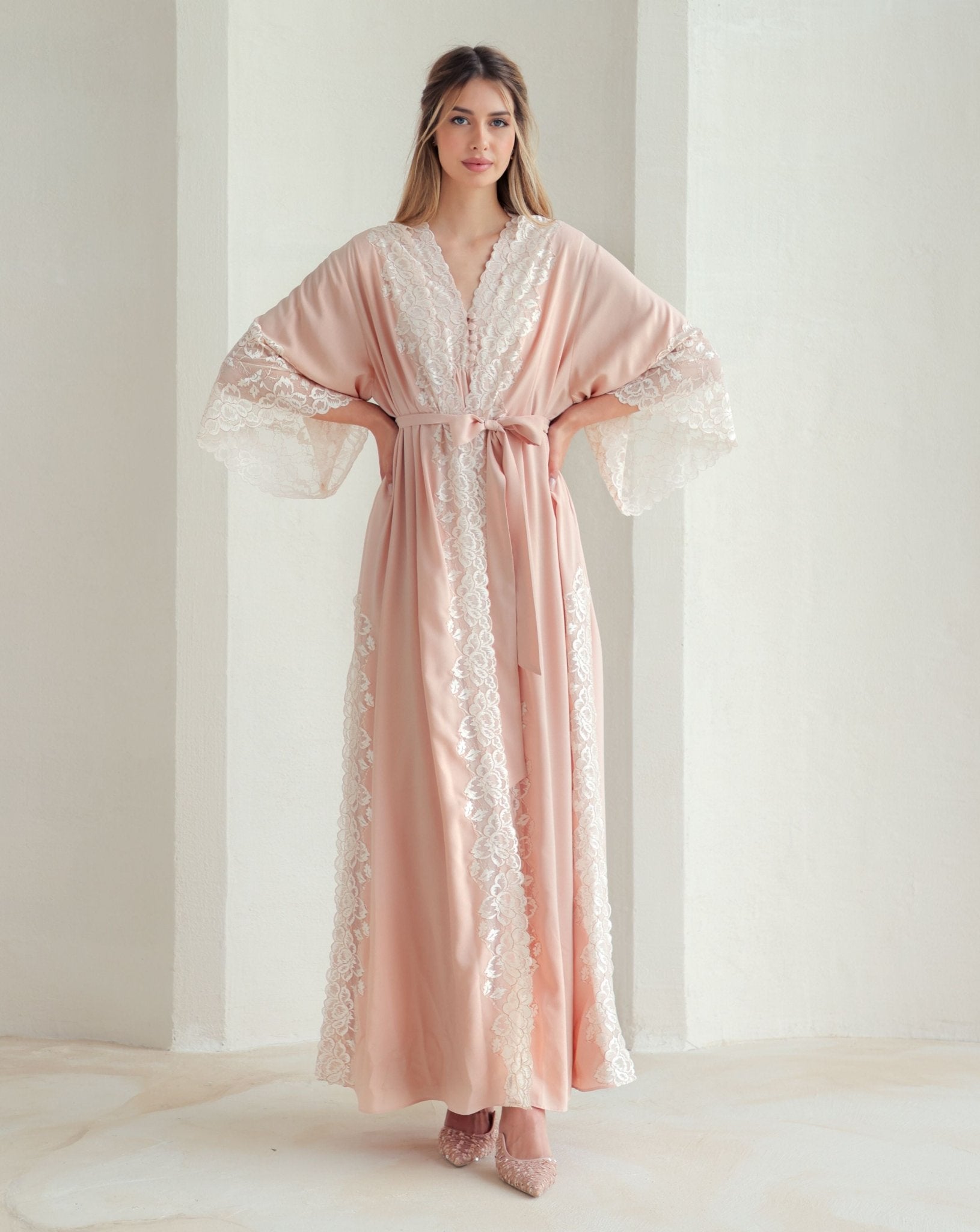 Standing in a belted robe with hands on the waist, highlighting the gentle support and comfortable wrap-over style.
