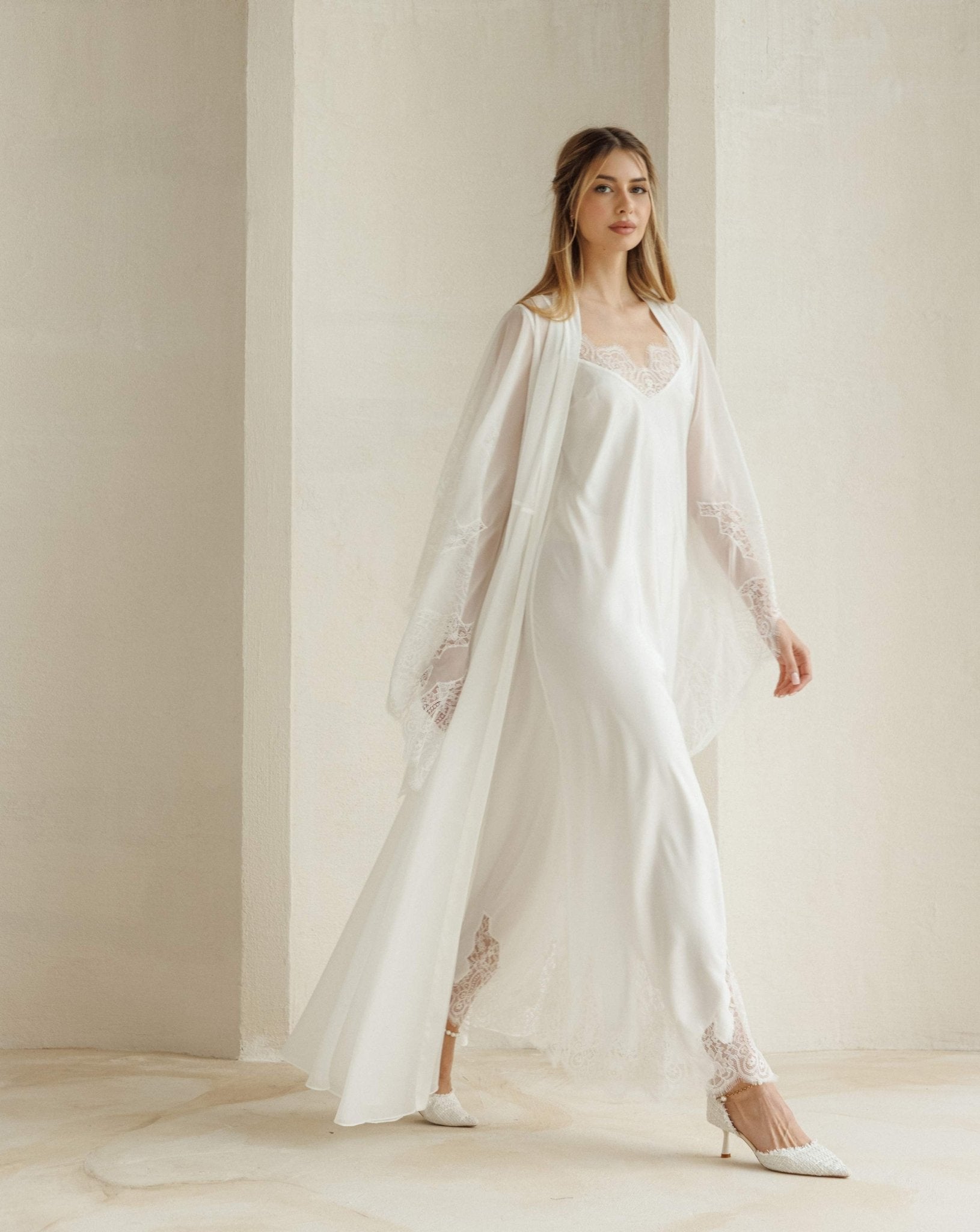 White Robe and Nightgown Set in motion, featuring a long flowing silhouette and delicate lace detailing.