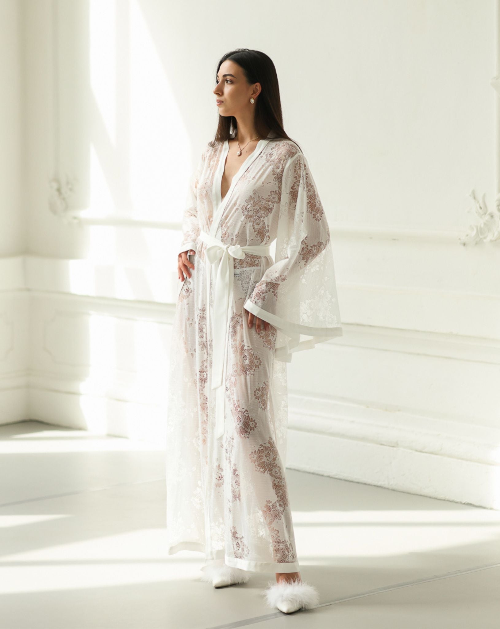 Side full-length view of a long lace wrap, showcasing the graceful silhouette and flowing floral patterns.