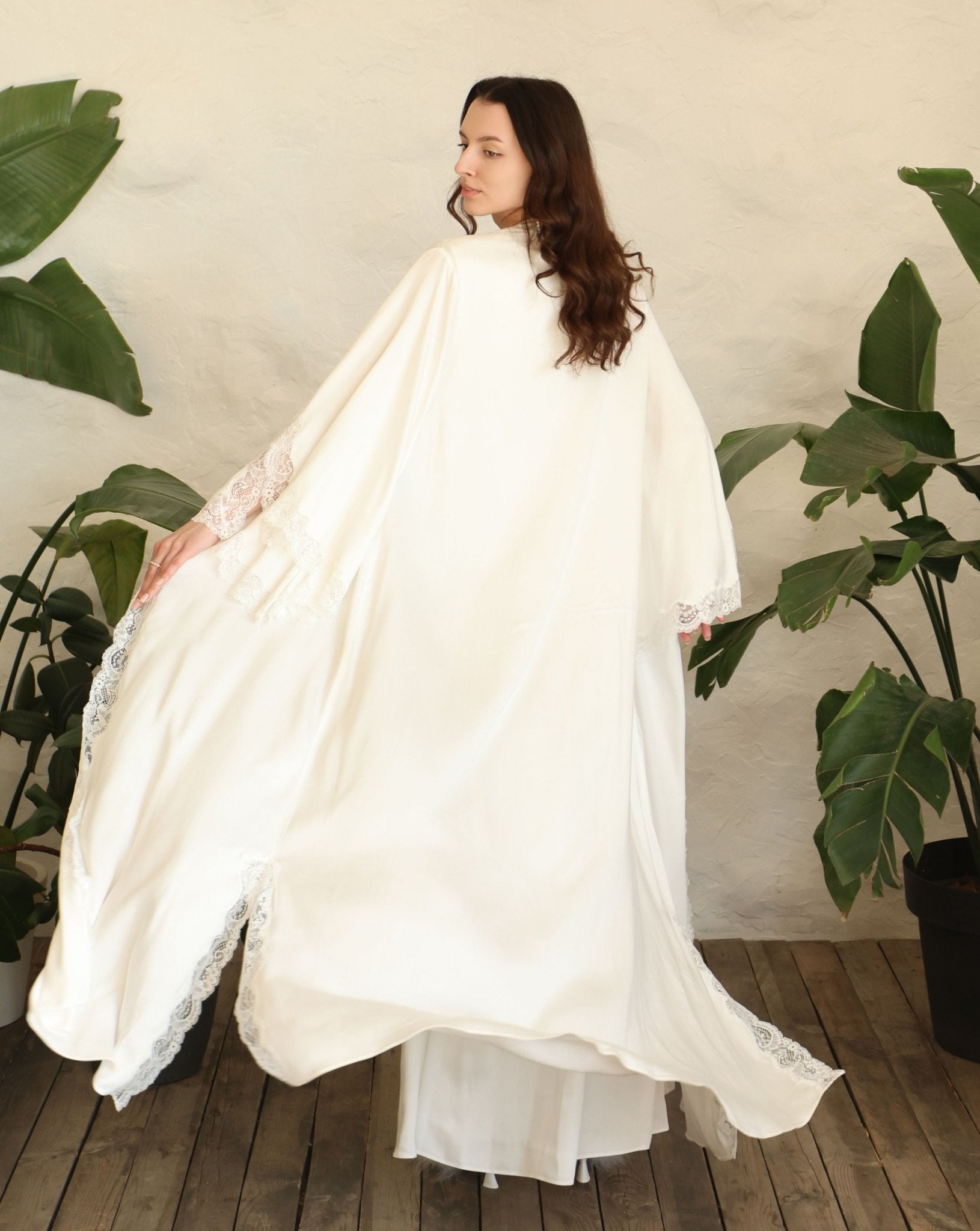 Rear view of the robe in motion, capturing the graceful movement and the serene beauty of the long silhouette.
