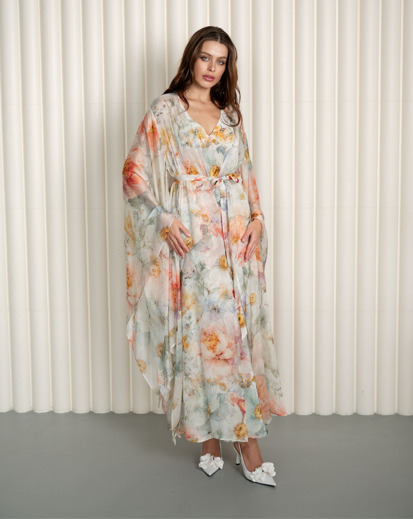 Model twirling in floral silk robe and nightgown set