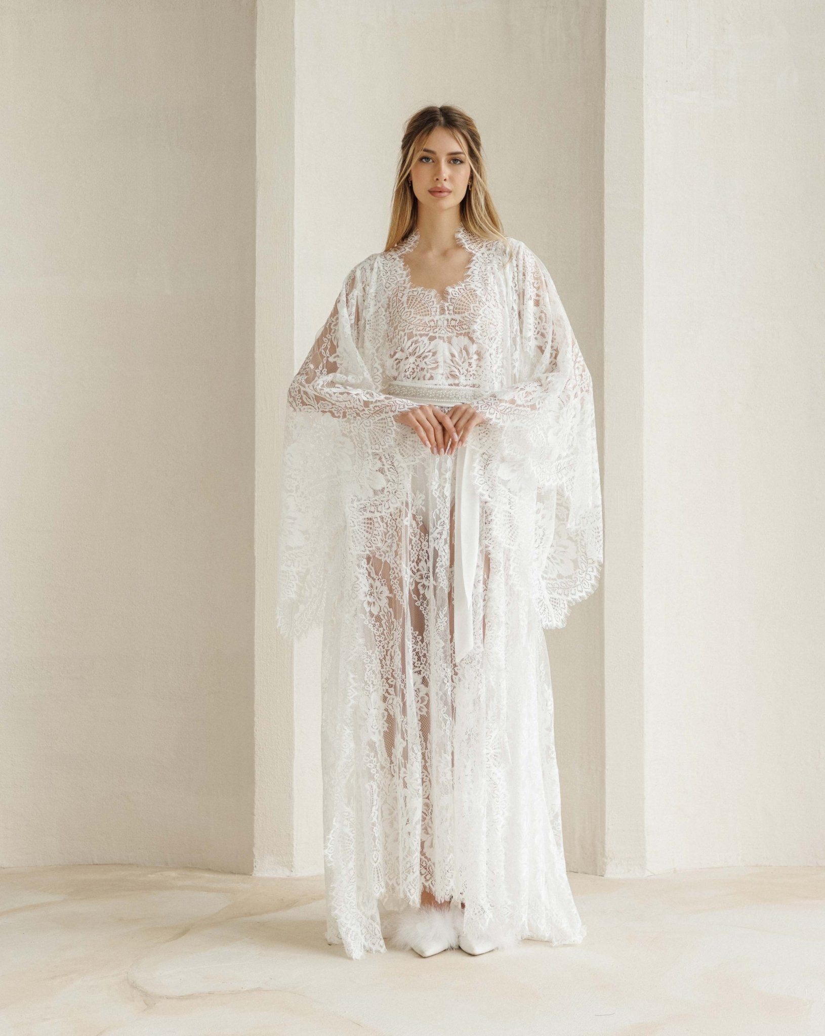 Full-length view of the lace ensemble with hands at the waist, highlighting the refined and light silhouette.