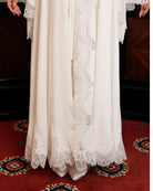 Close-up of the lower part of the ensemble, highlighting the quality of the lace and the sweeping length.